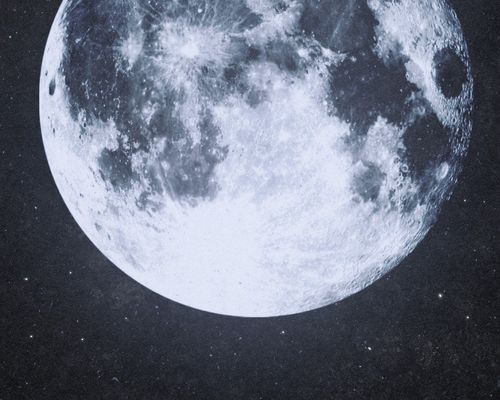 A boat in a ocean of water sitting below a bright moon